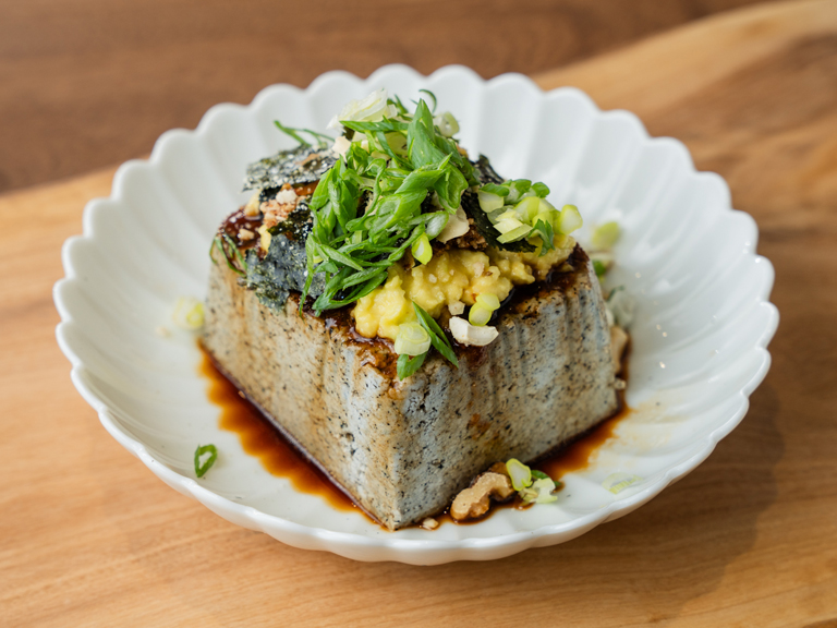 「芝麻豆腐」可以開封即食，非常適合忙碌的現代人。無論是涼拌、煎炒還是燉煮，它都能輕鬆融入各式料理中，鹹甜皆宜，為菜餚增添獨特的芝麻香氣與豆腐的扎實口感，讓你的每一餐都更豐富、美味，賦予菜餚獨特風味。 | 改變生命的豆漿店 | 禾乃川國產豆製所
